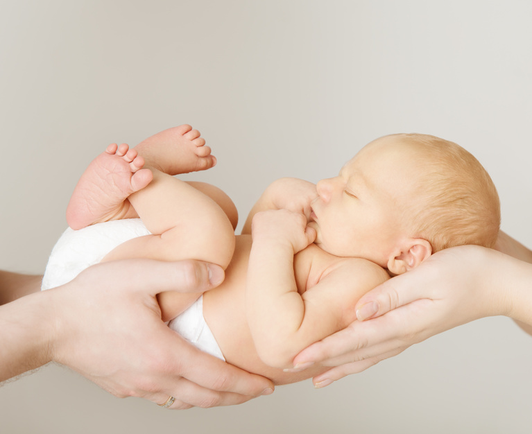 neugeborenes Baby in den Händen der Eltern